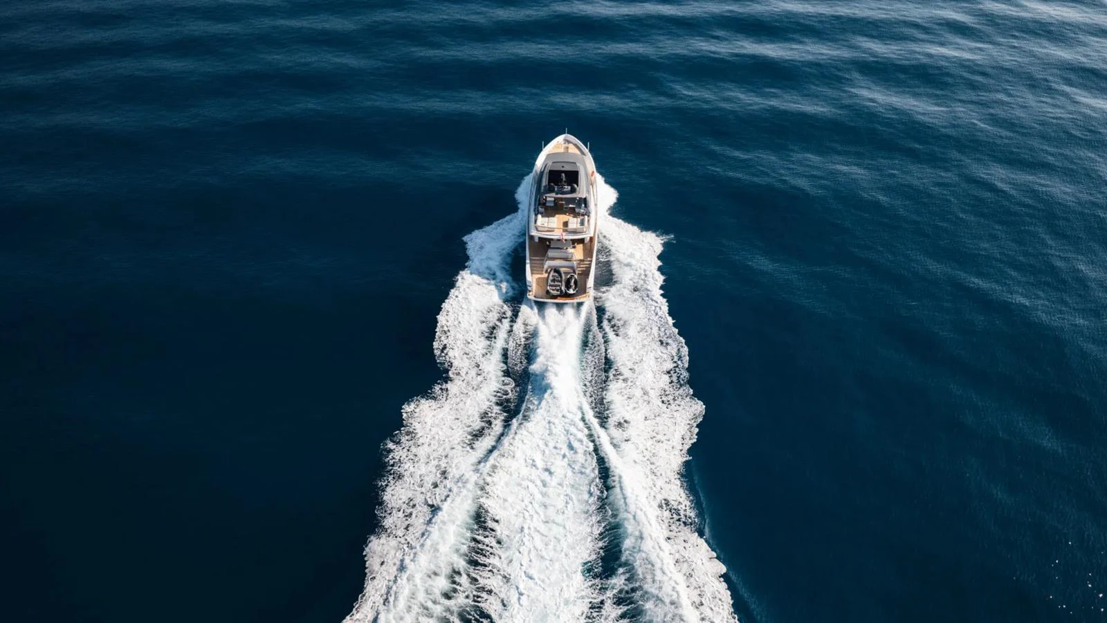 A yacht cruises through the open sea, leaving a trail of white wake behind. aboard LA Yacht for Sale