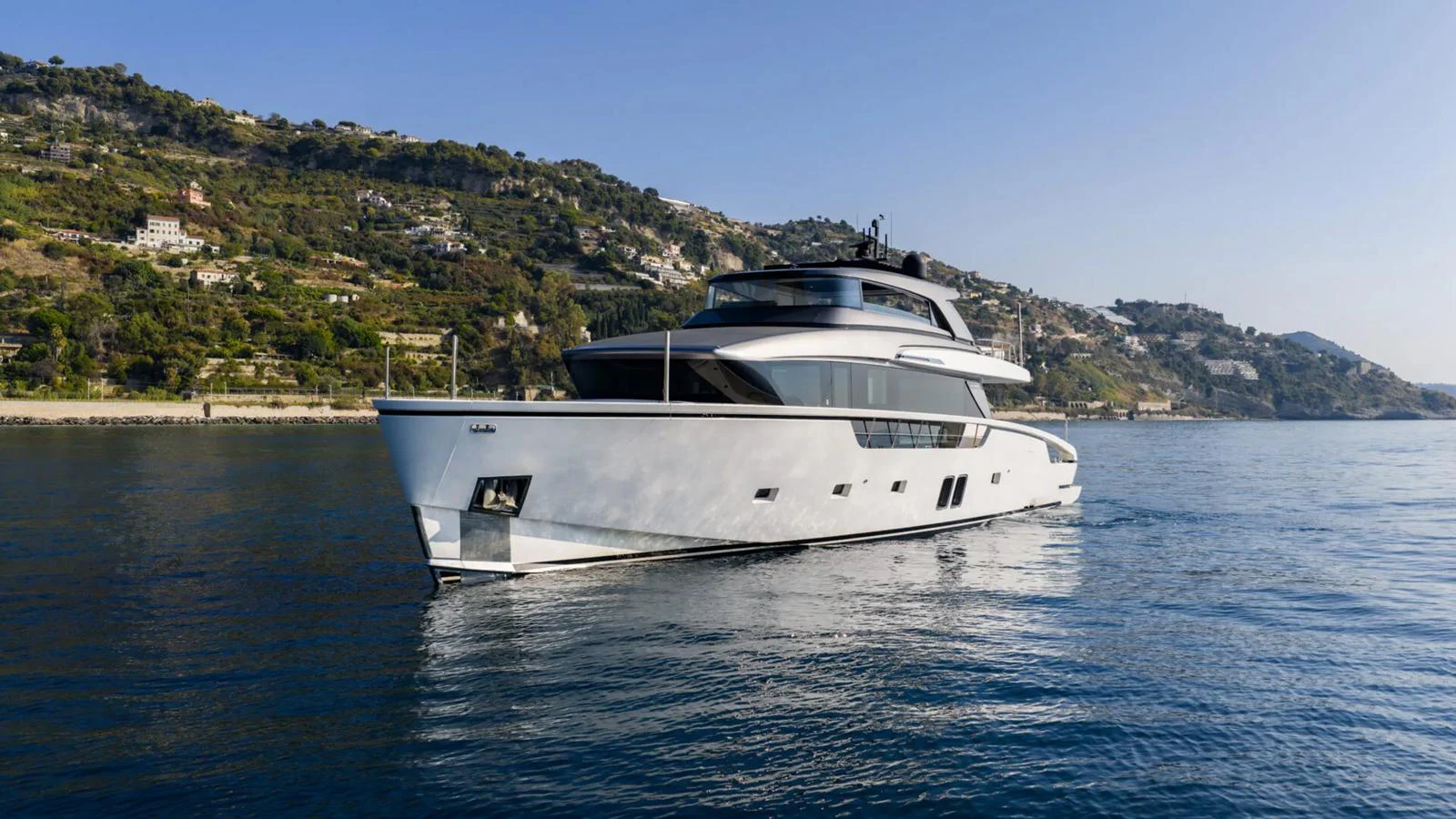 A sleek and modern yacht cruising along a picturesque coastline. aboard LA Yacht for Sale