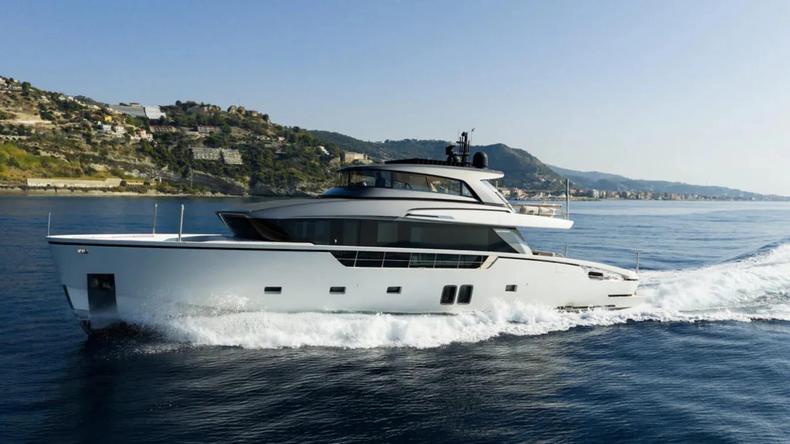 A sleek and modern yacht cruising along a picturesque coastline. aboard LA Yacht for Sale