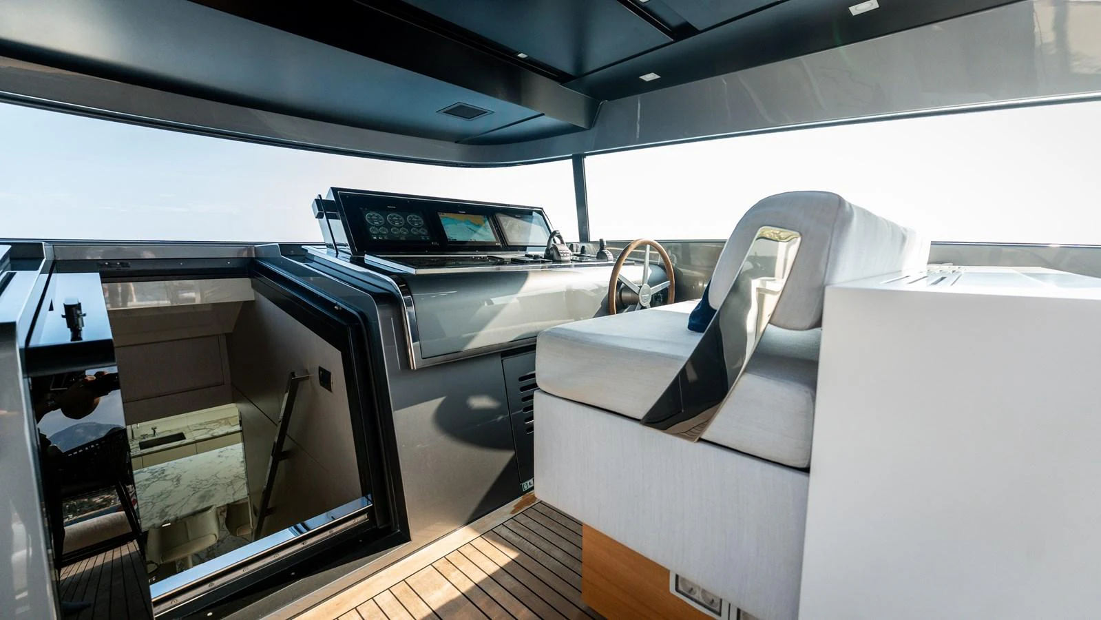 The helm station features modern navigation equipment and a comfortable captain's chair with a sleek, contemporary design. aboard LA Yacht for Sale