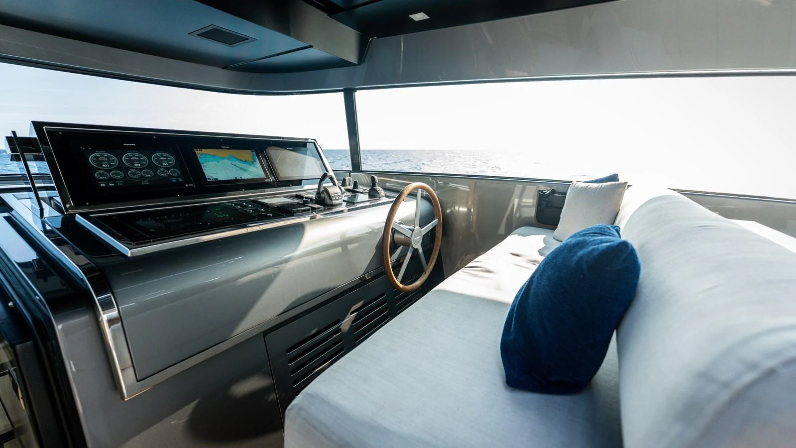 The helm station features modern navigation equipment and a comfortable seating area with a panoramic view. aboard LA Yacht for Sale