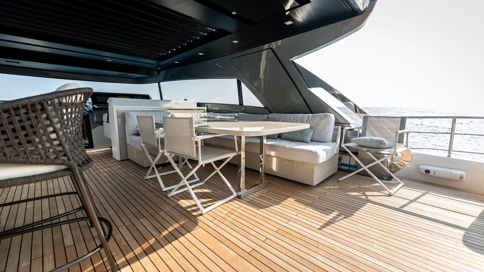 The aft deck offers a spacious and comfortable outdoor seating area with a dining table, perfect for alfresco dining and relaxation. aboard LA Yacht for Sale