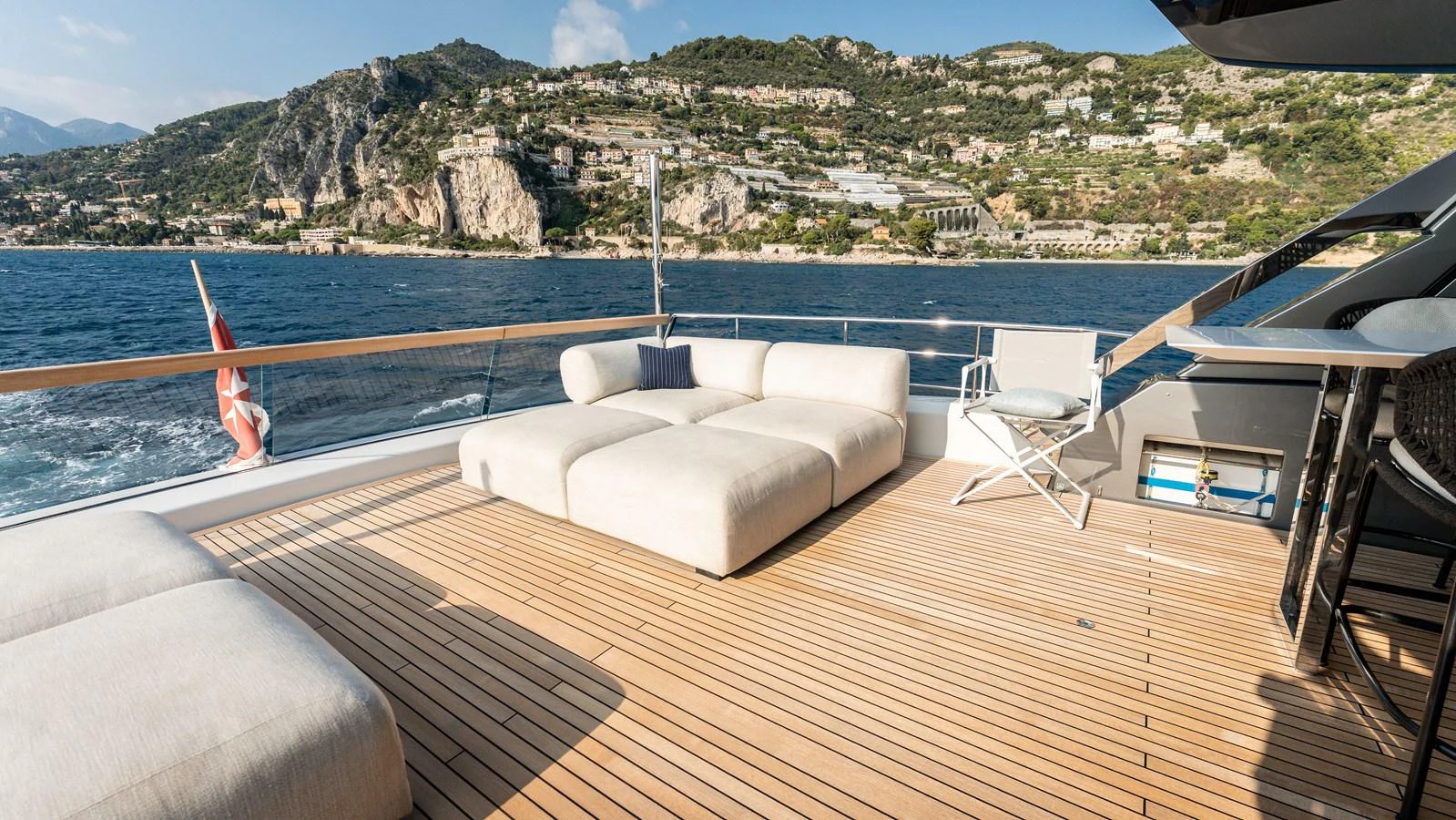 The yacht's aft deck features luxurious seating with stunning views of the coastline. aboard LA Yacht for Sale