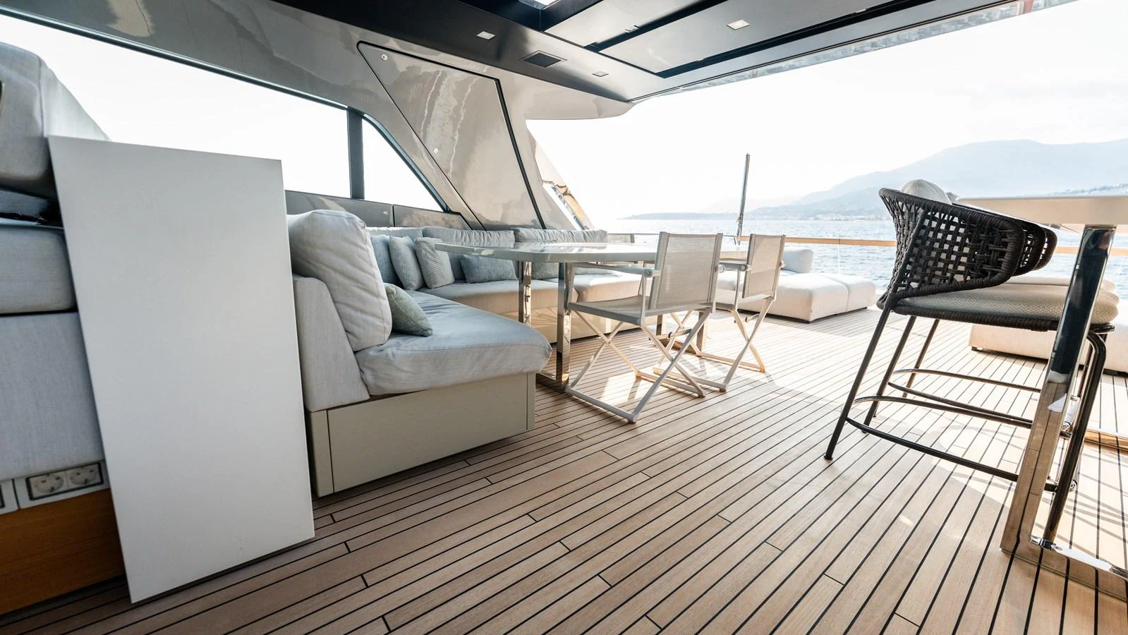 The aft deck features a spacious seating area with a dining table, perfect for alfresco dining and relaxation. aboard LA Yacht for Sale