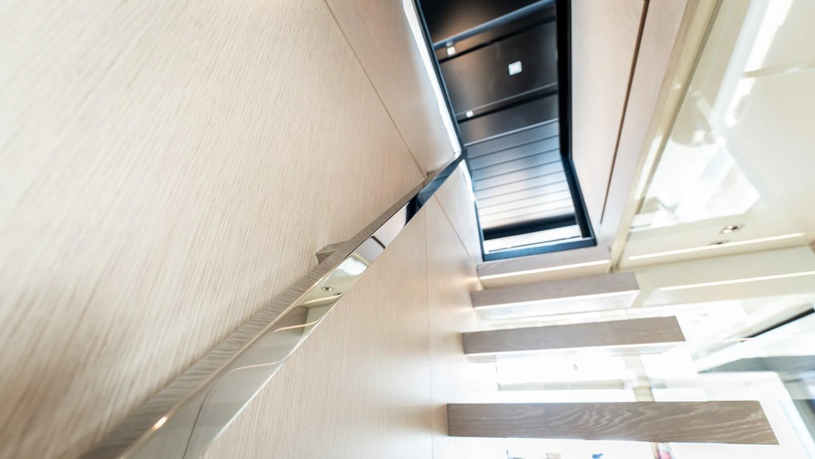 A modern staircase with sleek, minimalist design elements inside the yacht. aboard LA Yacht for Sale