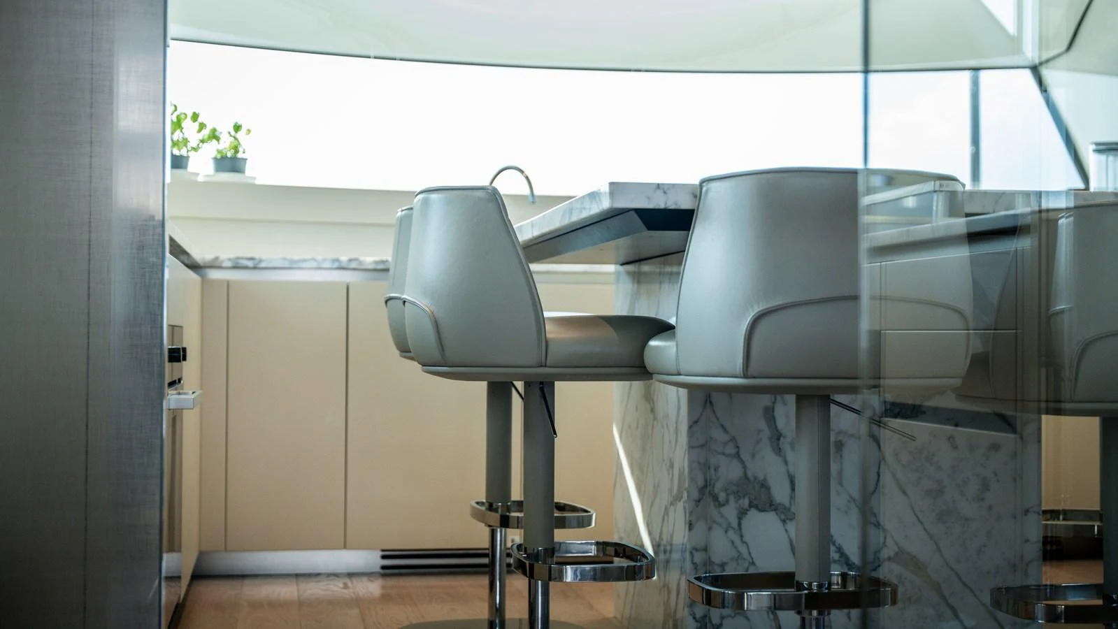 The yacht's galley features modern bar stools and a sleek marble countertop, creating a sophisticated dining area. aboard LA Yacht for Sale