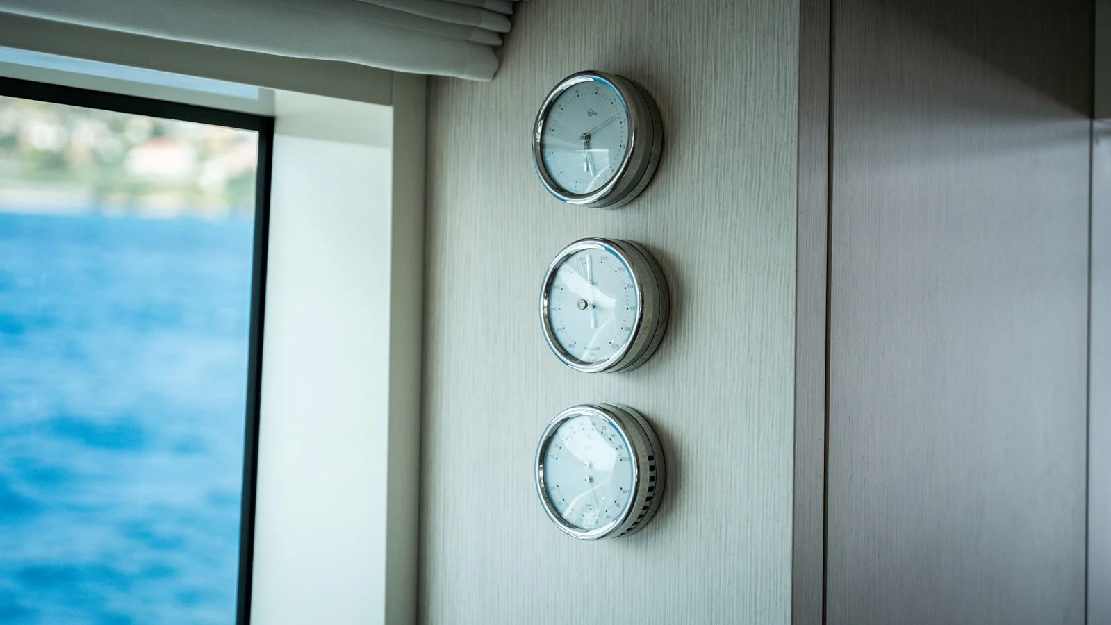 A close-up of three nautical instruments mounted on a wall inside the yacht. aboard LA Yacht for Sale