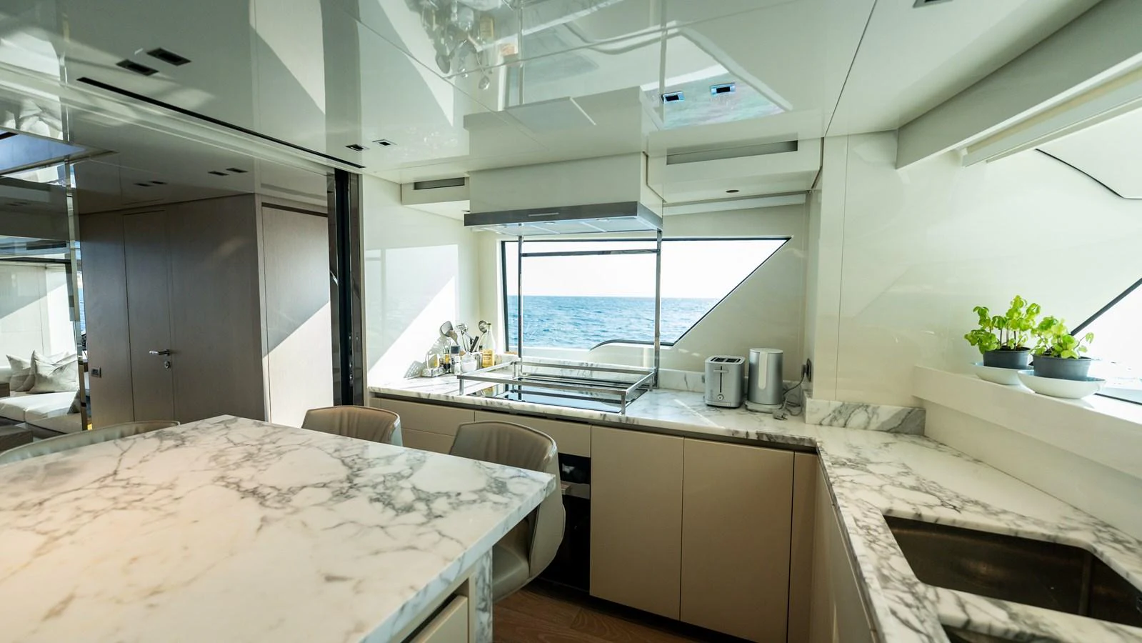 The yacht's galley features sleek, modern design with marble countertops and ample natural light. aboard LA Yacht for Sale