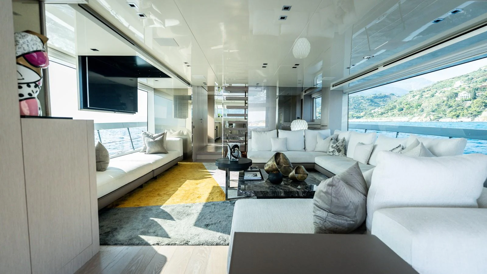 The salon offers a spacious and luxurious seating area with modern decor and large windows providing stunning views. aboard LA Yacht for Sale