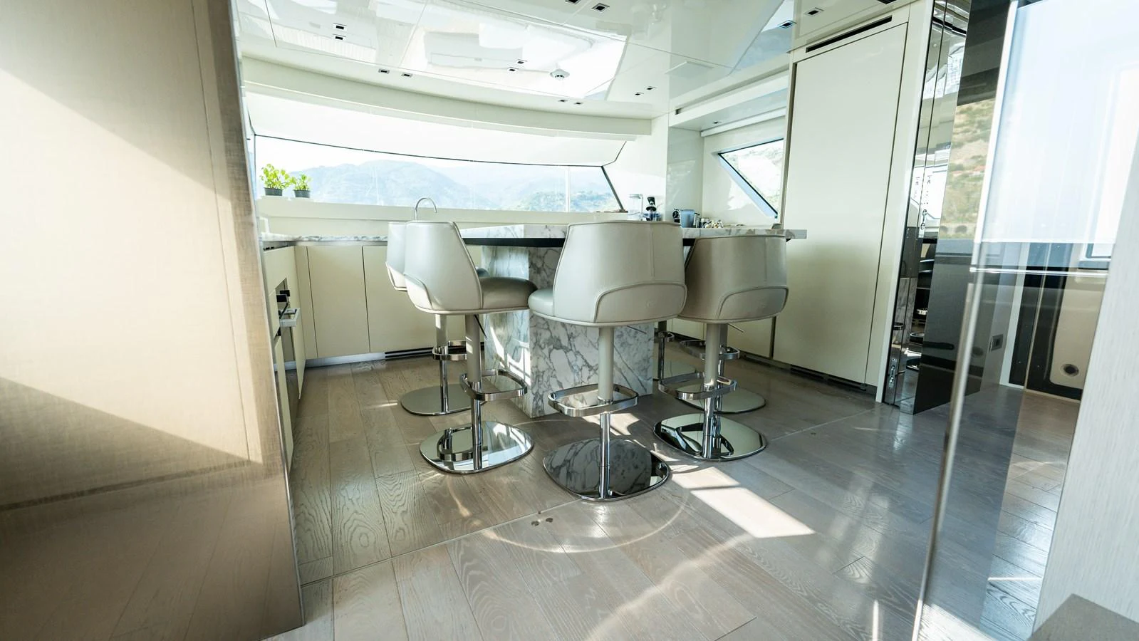 The yacht's galley features a modern design with a sleek bar counter and comfortable seating. aboard LA Yacht for Sale