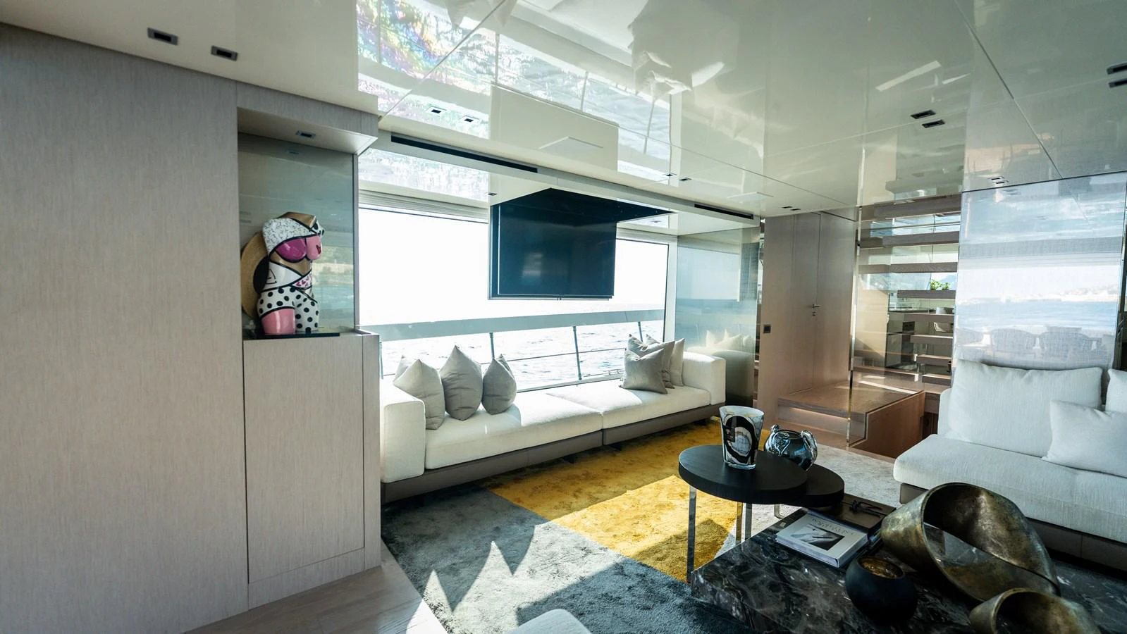 The salon features a spacious and modern design with ample seating and a large window offering stunning views. aboard LA Yacht for Sale