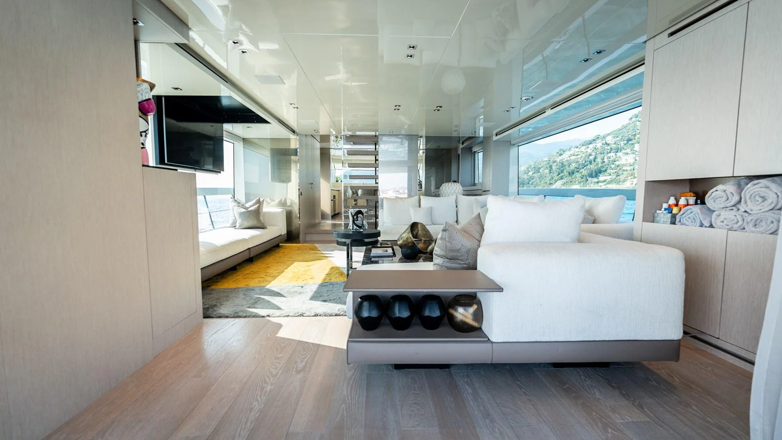 The salon features luxurious seating with ample natural light and scenic views. aboard LA Yacht for Sale