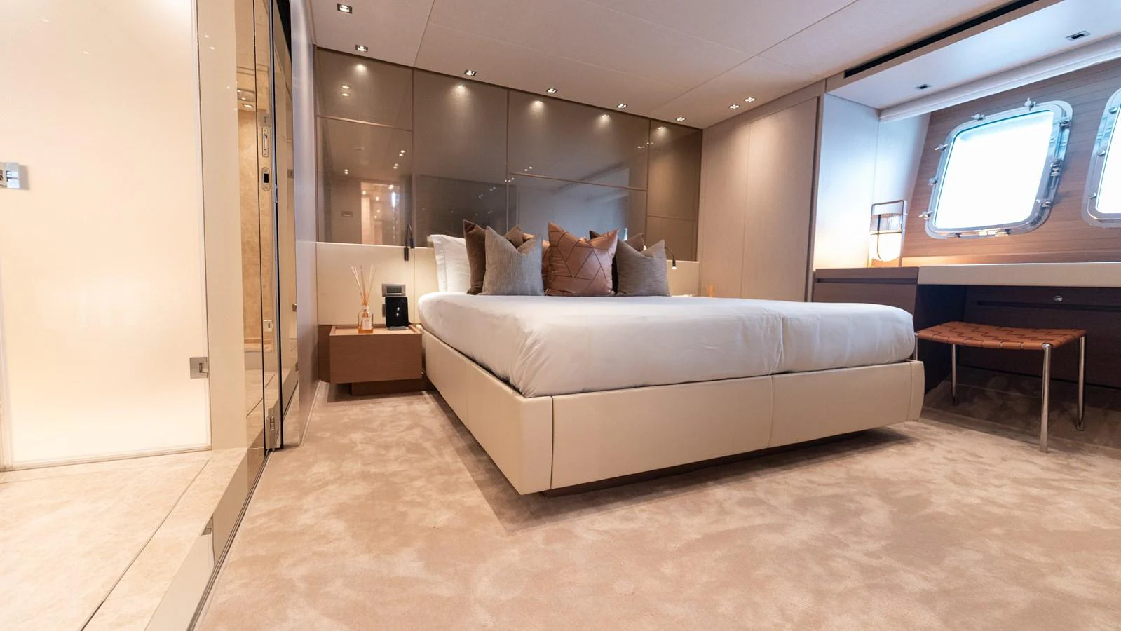 The master stateroom features a luxurious bed, ample lighting, and a large window for natural light. aboard LA Yacht for Sale