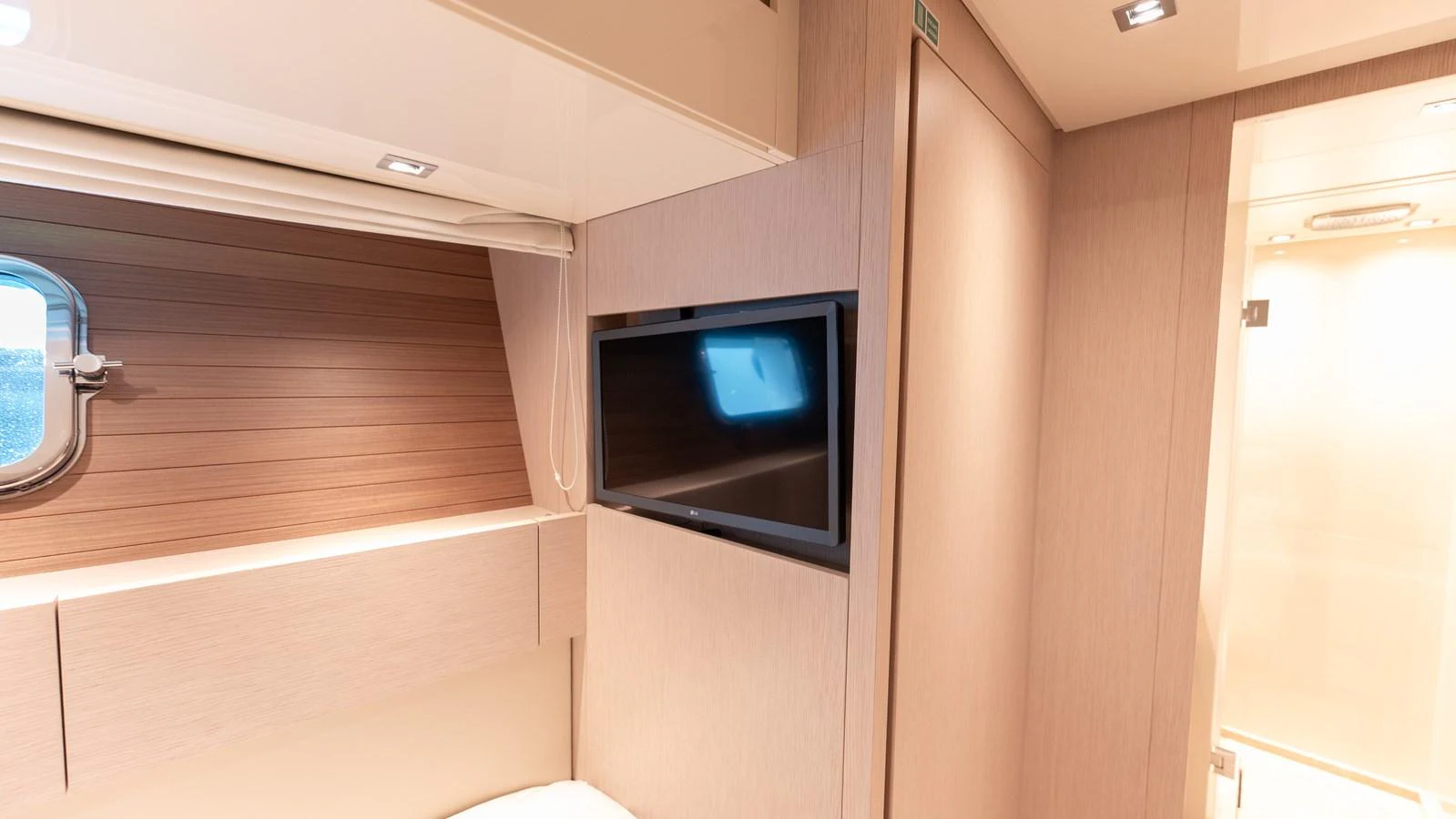 The yacht's interior features a cozy cabin with a television and a window providing natural light. aboard LA Yacht for Sale