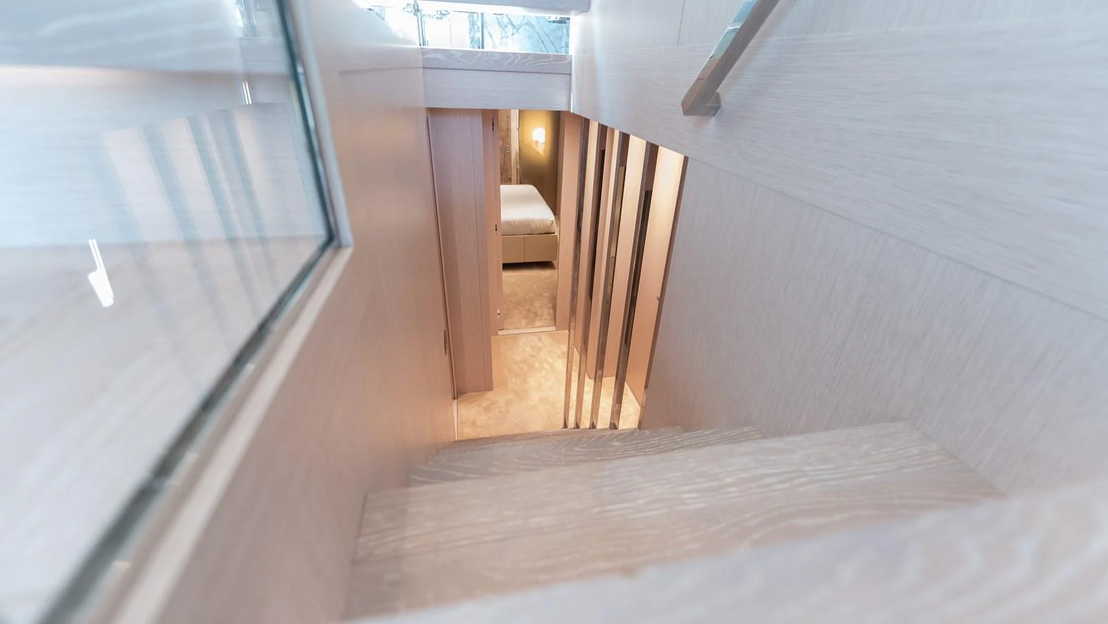 A modern staircase leads down to a cozy stateroom. aboard LA Yacht for Sale