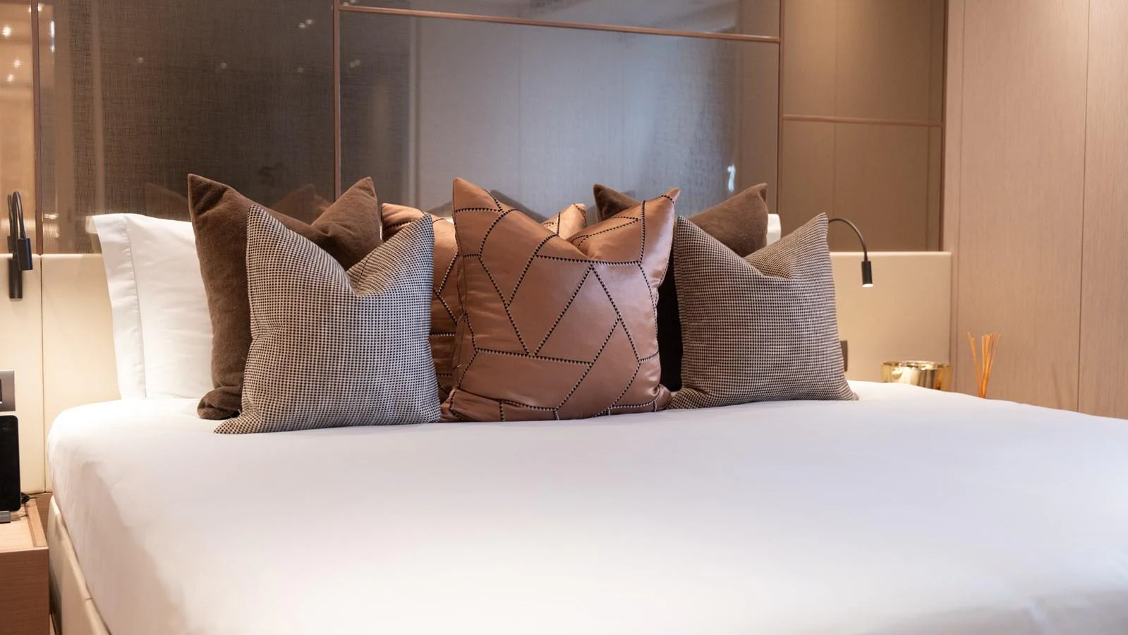 A luxurious stateroom featuring a plush bed adorned with elegant pillows. aboard LA Yacht for Sale