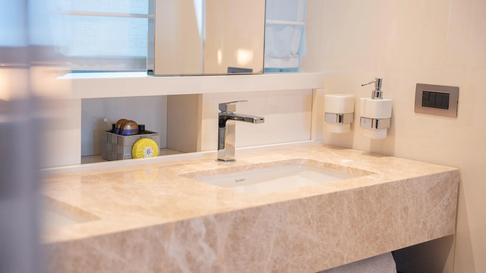 The yacht's bathroom features a sleek, modern sink area with elegant fixtures and ample counter space. aboard LA Yacht for Sale