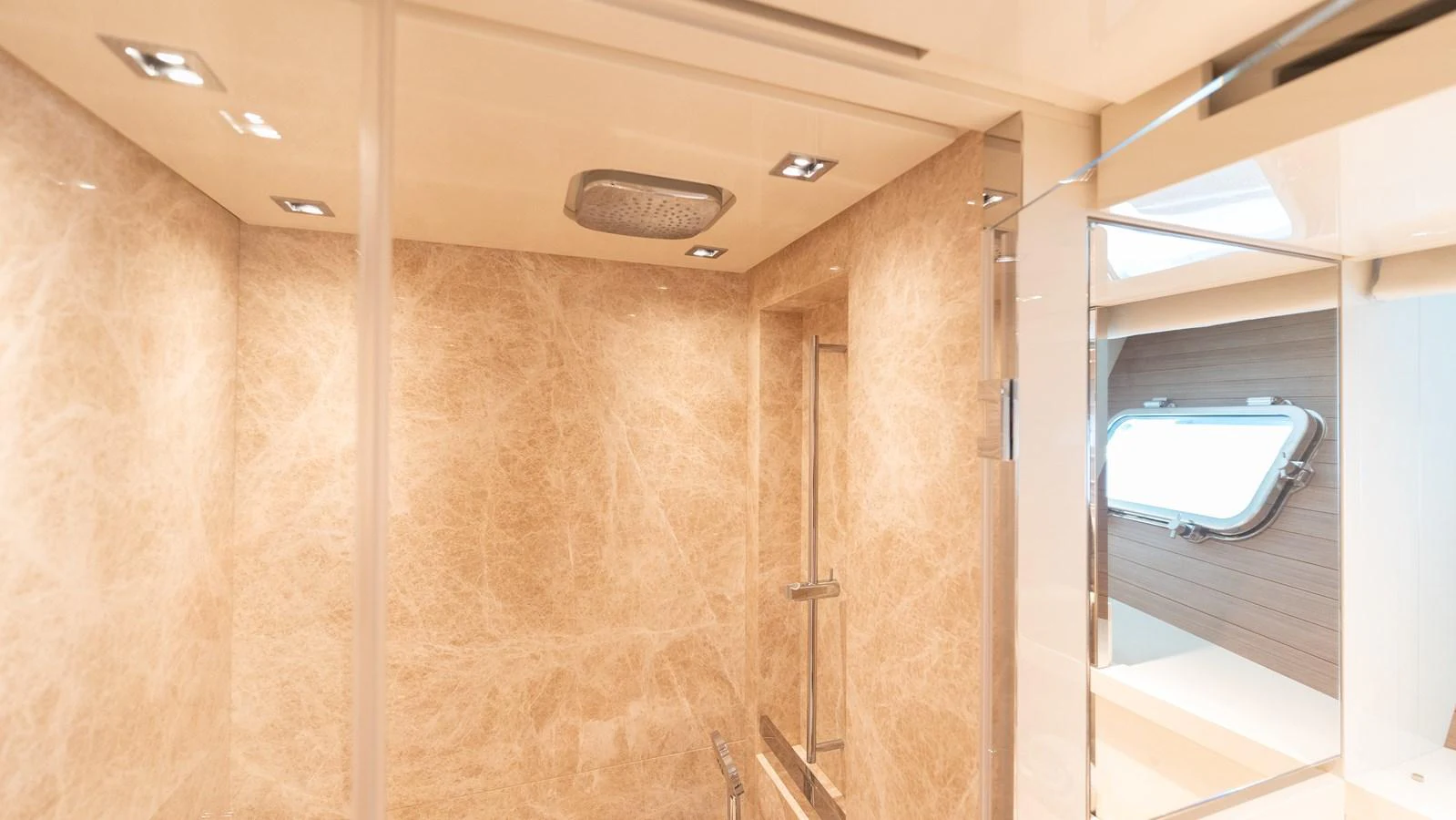 The yacht's bathroom features elegant marble walls and a modern shower area. aboard LA Yacht for Sale