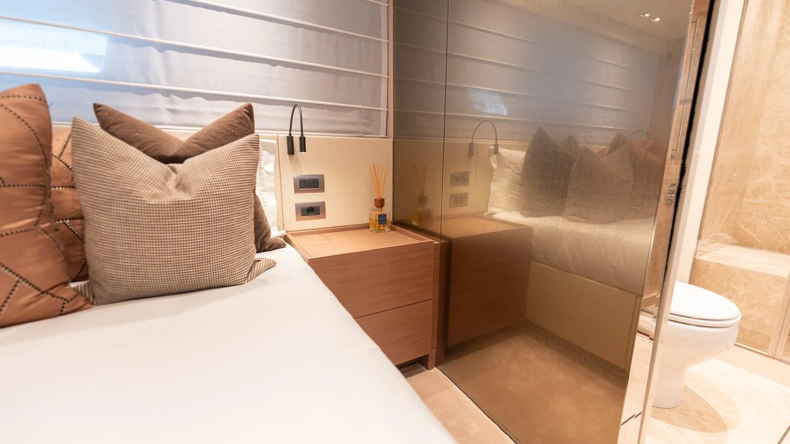 The guest stateroom features a cozy bed with plush pillows and a modern ensuite bathroom. aboard LA Yacht for Sale