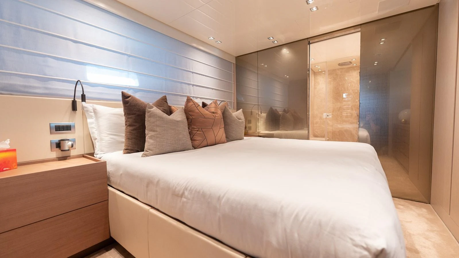 The stateroom features a plush bed with elegant decor and modern lighting. aboard LA Yacht for Sale
