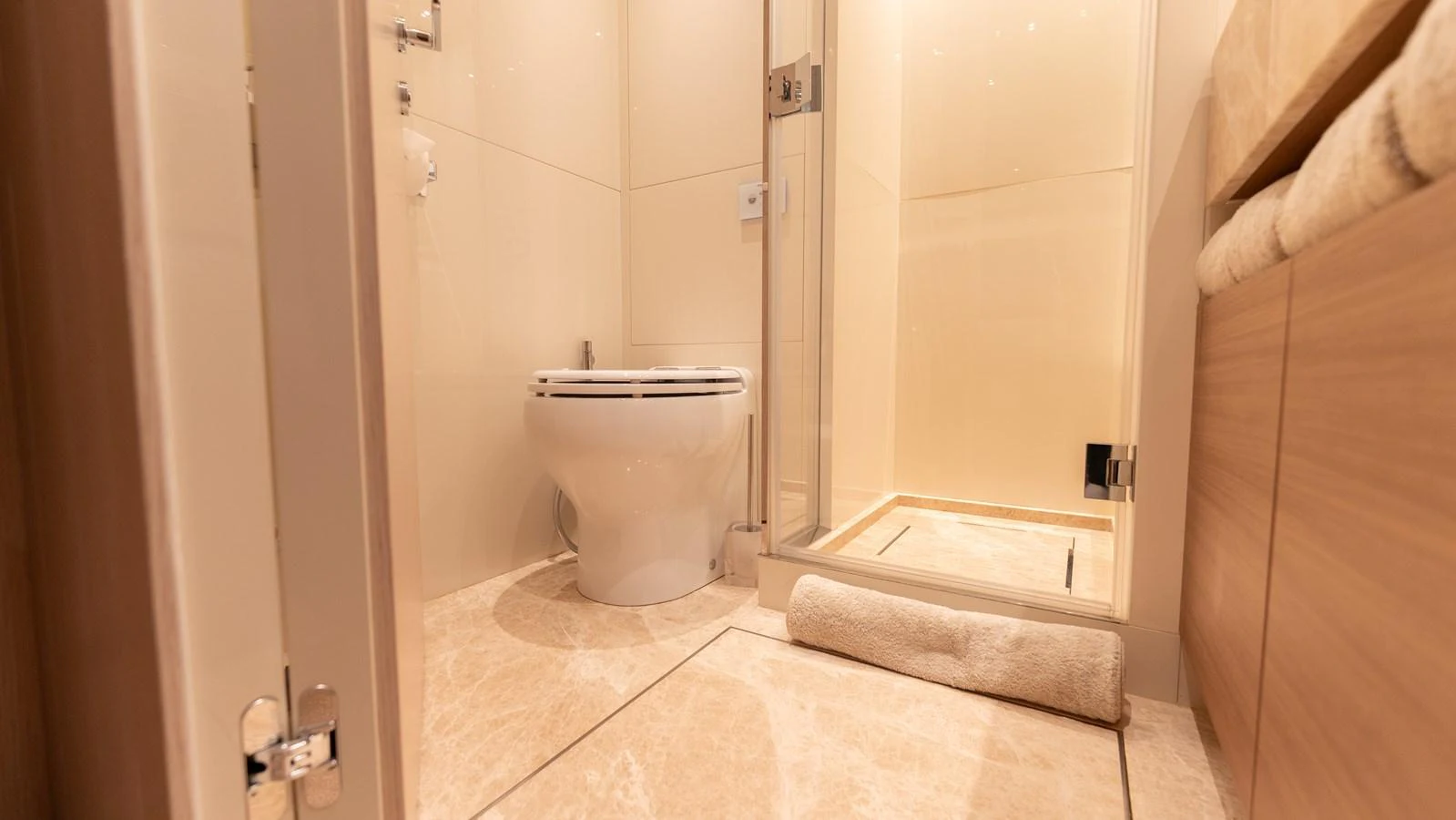 The yacht's bathroom features a modern design with a glass-enclosed shower and elegant fixtures. aboard LA Yacht for Sale
