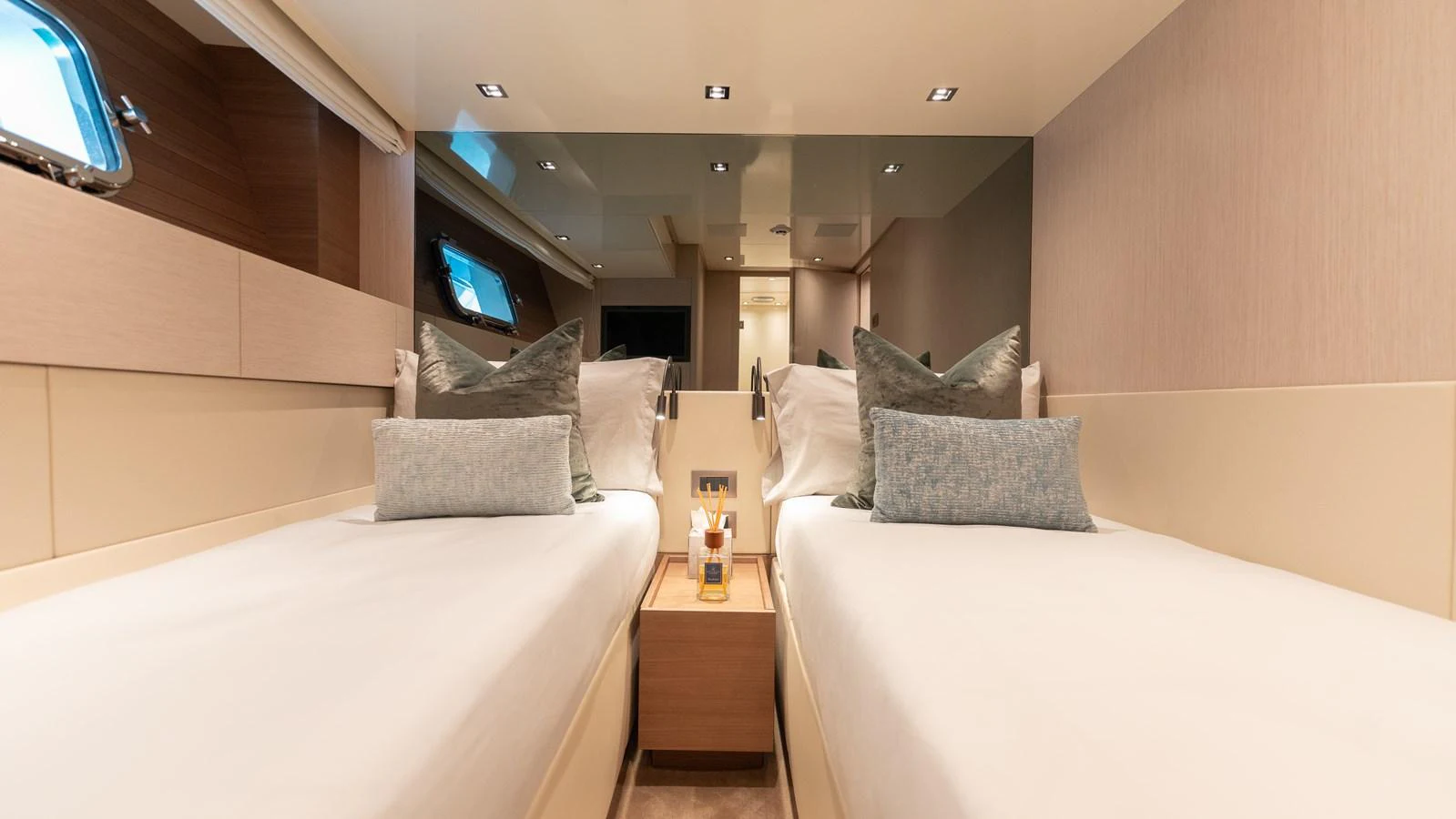 The guest stateroom features twin beds with plush bedding and a modern, elegant design. aboard LA Yacht for Sale