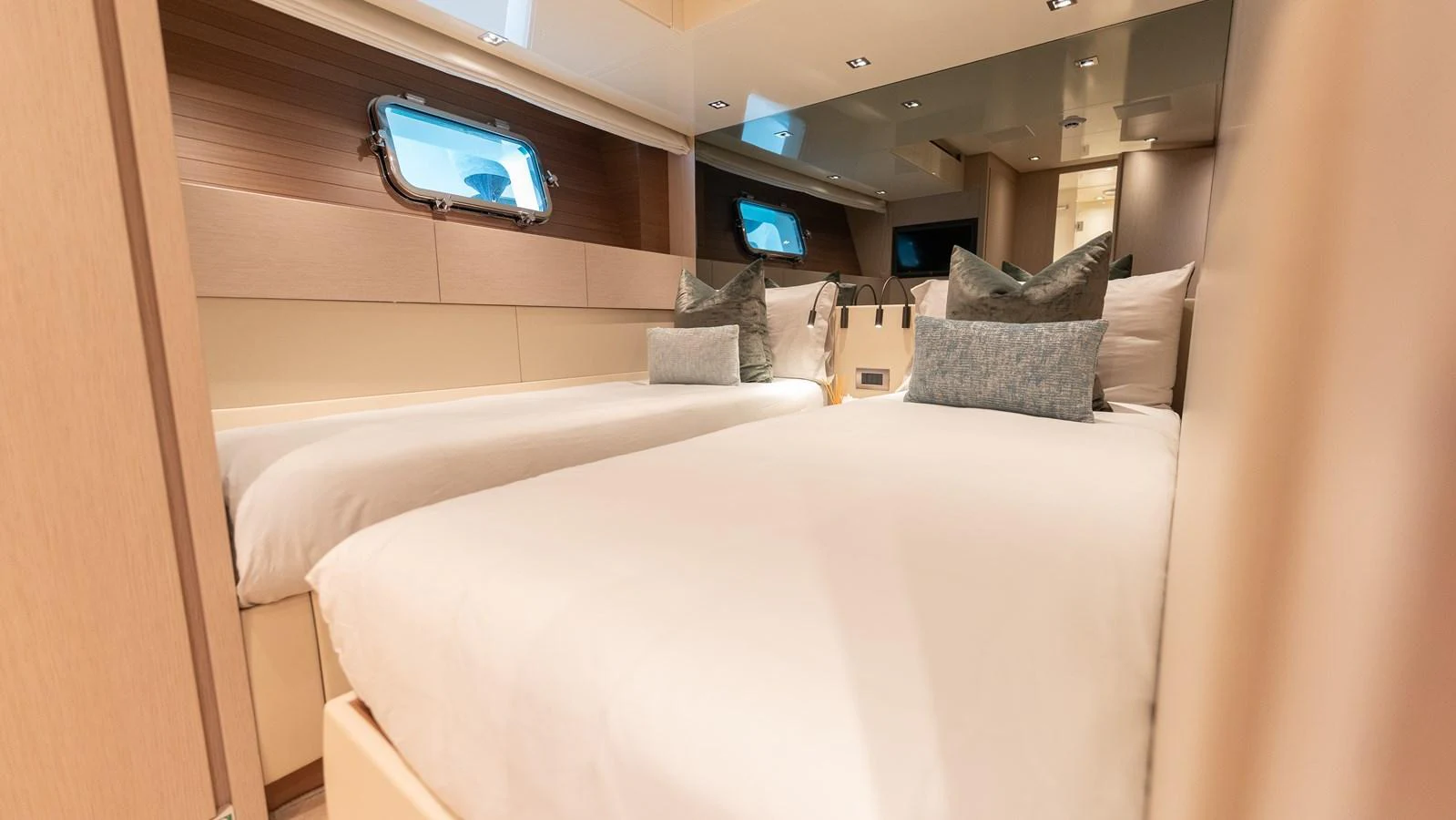 The guest stateroom features twin beds with plush bedding and modern decor. aboard LA Yacht for Sale