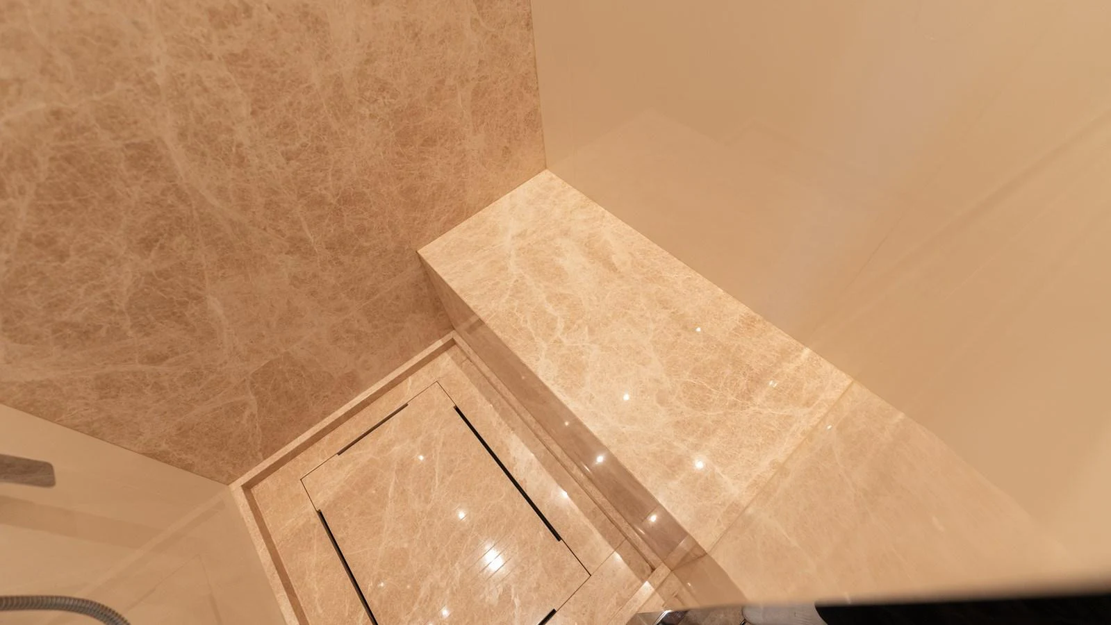 The image showcases a luxurious marble-finished bathroom area on the yacht. aboard LA Yacht for Sale
