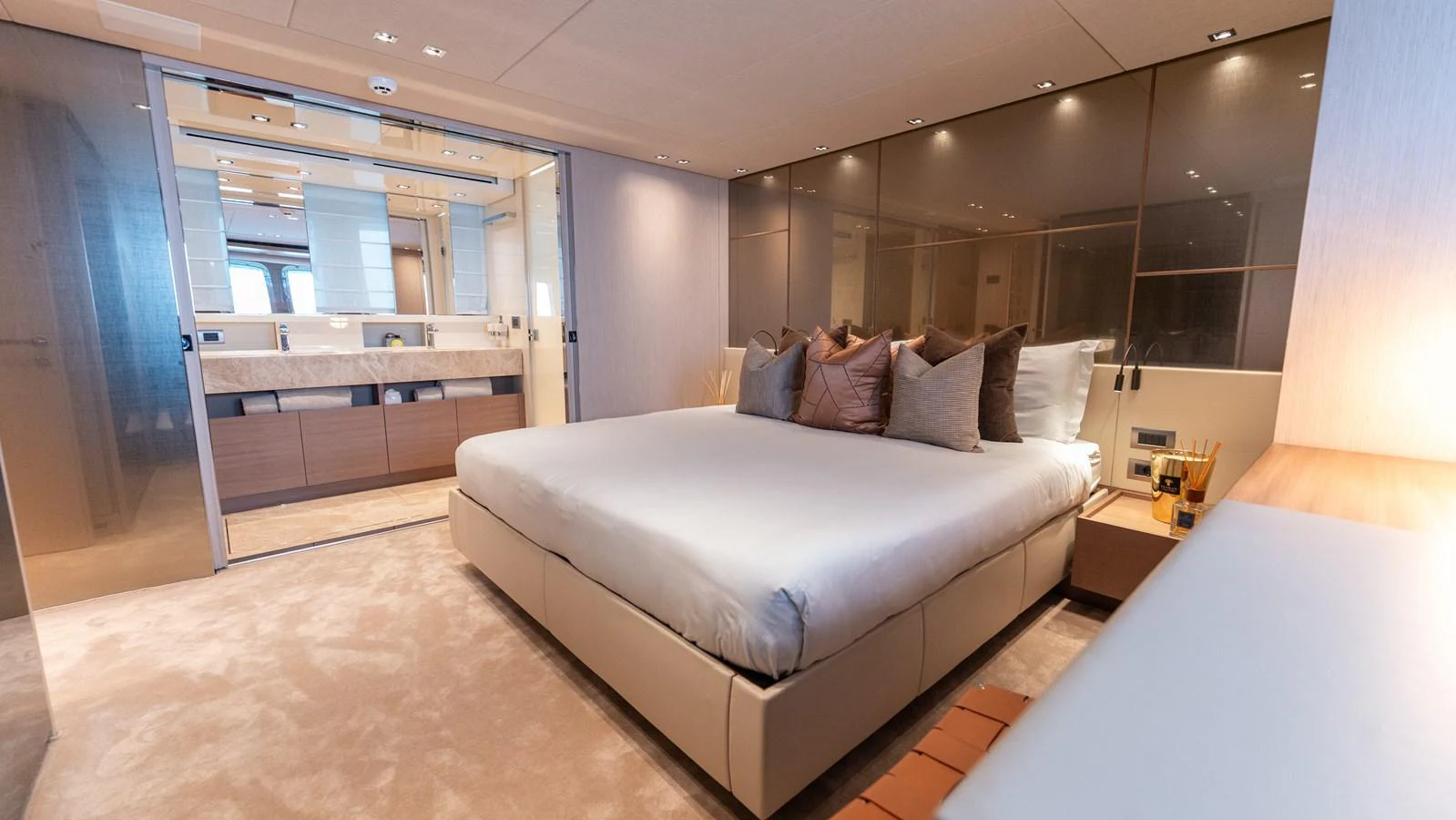 The master stateroom features a luxurious bed and modern decor with an ensuite bathroom. aboard LA Yacht for Sale