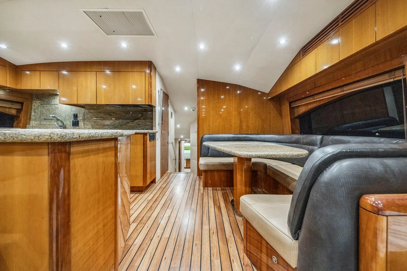 The yacht's salon features a cozy dining area with a polished wood finish and modern lighting. aboard REEL TEXAN Yacht for Sale