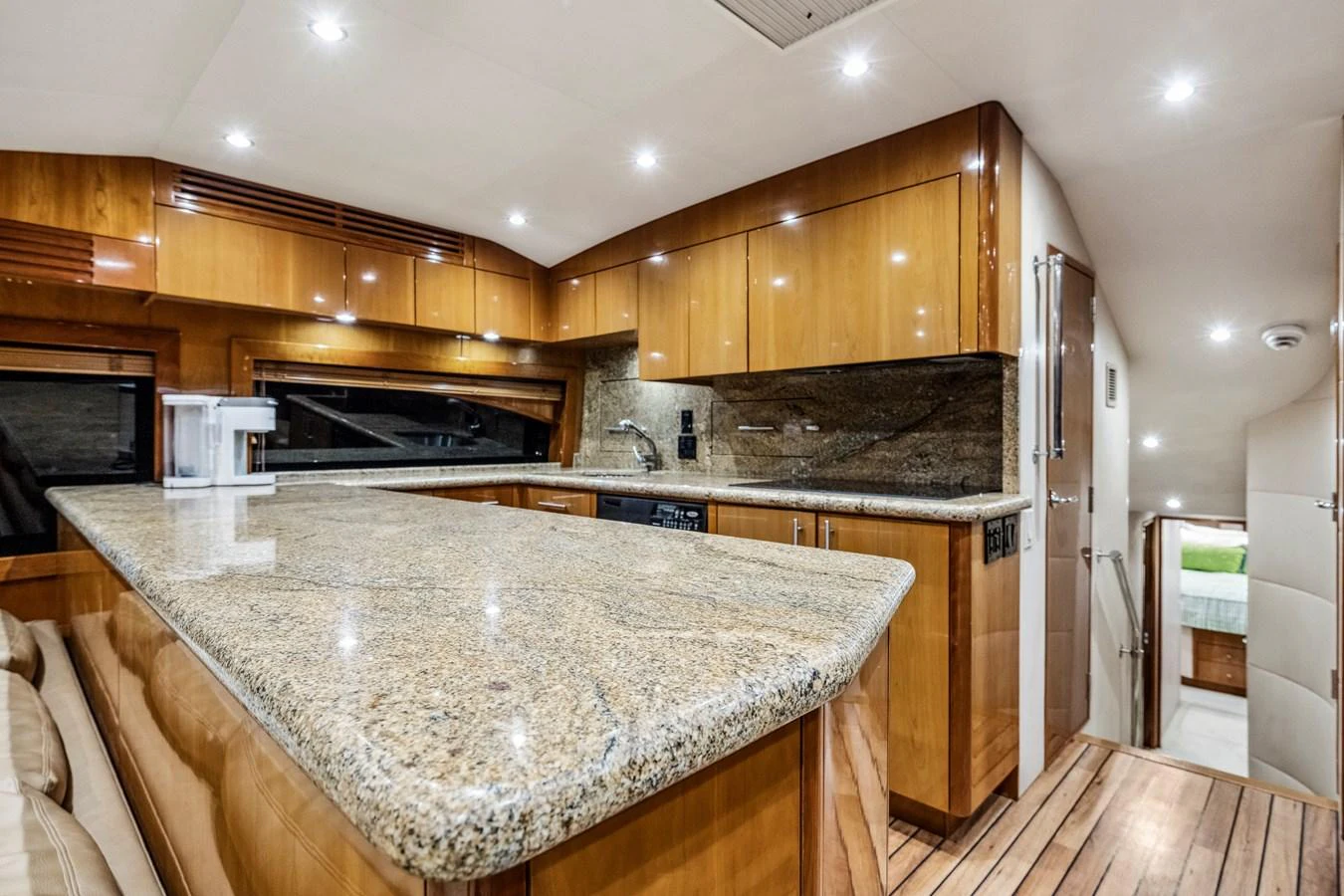 The yacht's galley features elegant wooden cabinetry and a spacious granite countertop. aboard REEL TEXAN Yacht for Sale