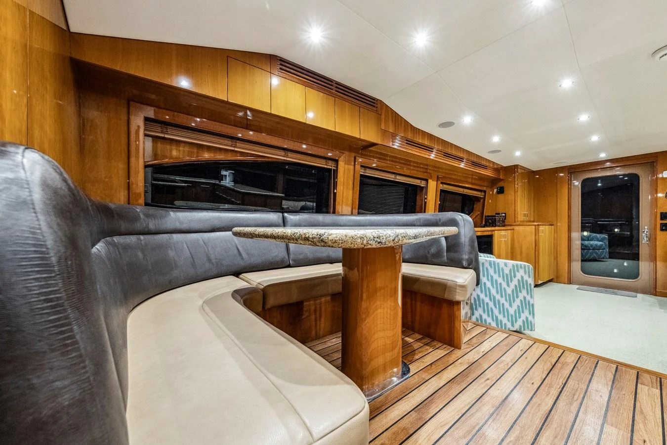 The salon features a cozy seating area with a polished wooden table and ample lighting. aboard REEL TEXAN Yacht for Sale