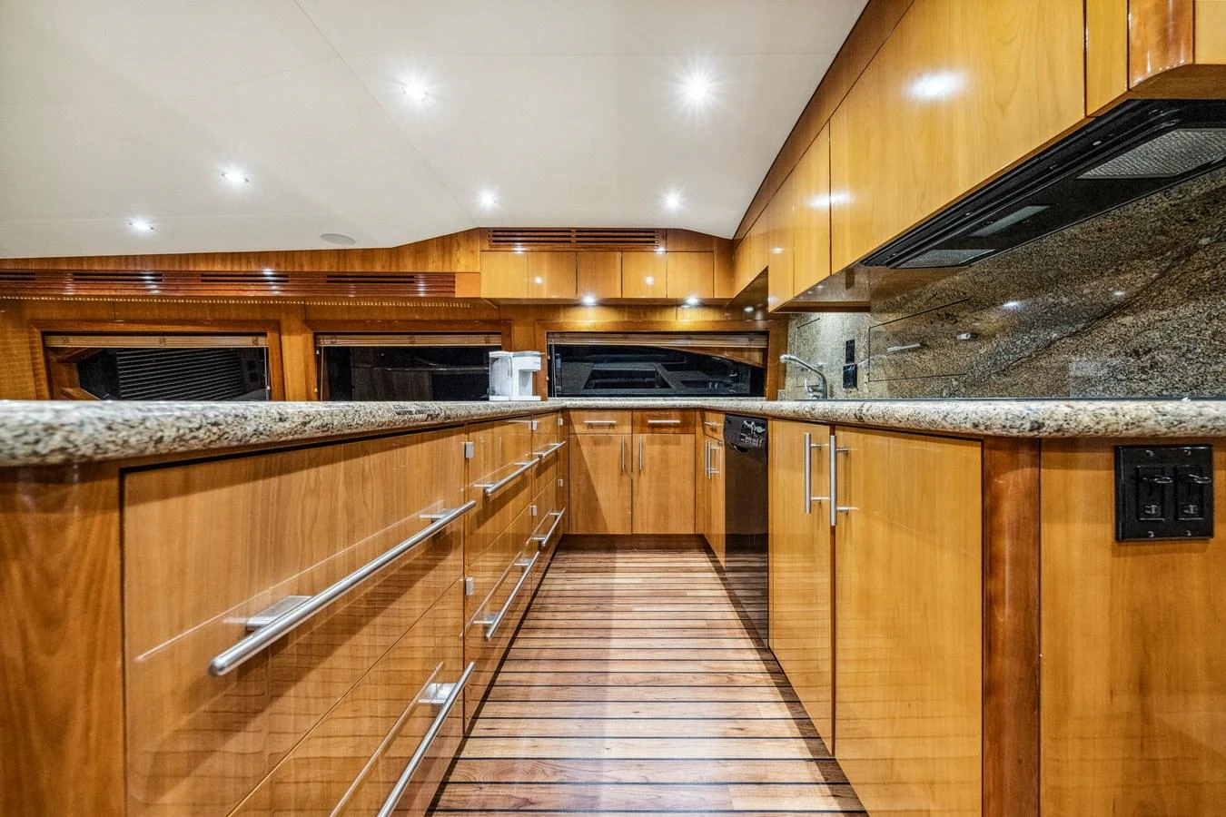 The galley features sleek wooden cabinetry and modern appliances, creating a warm and functional space. aboard REEL TEXAN Yacht for Sale