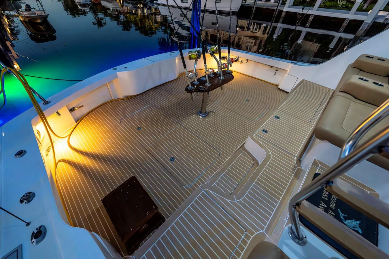 The aft deck features a spacious and well-lit area with comfortable seating and a stylish wooden floor. aboard REEL TEXAN Yacht for Sale