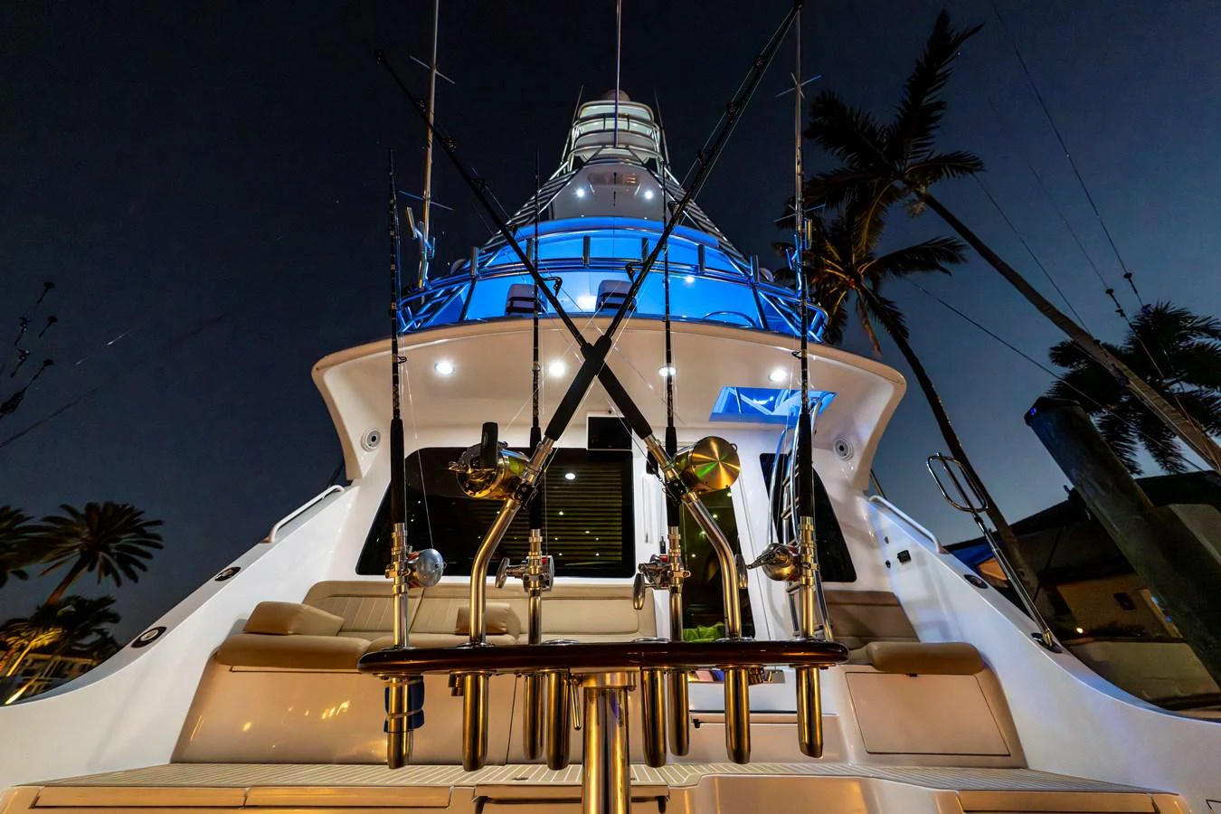 A stunning view of the yacht's stern, illuminated beautifully against the evening sky. aboard REEL TEXAN Yacht for Sale