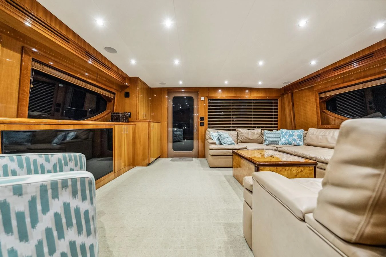 The salon features plush seating and elegant wood finishes, creating a warm and inviting atmosphere. aboard REEL TEXAN Yacht for Sale