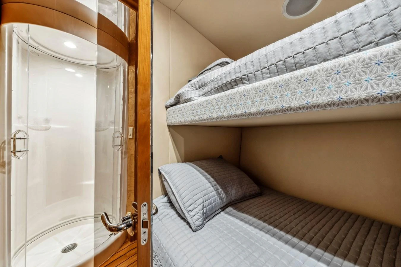 A cozy guest cabin featuring bunk beds and an adjacent shower area. aboard REEL TEXAN Yacht for Sale