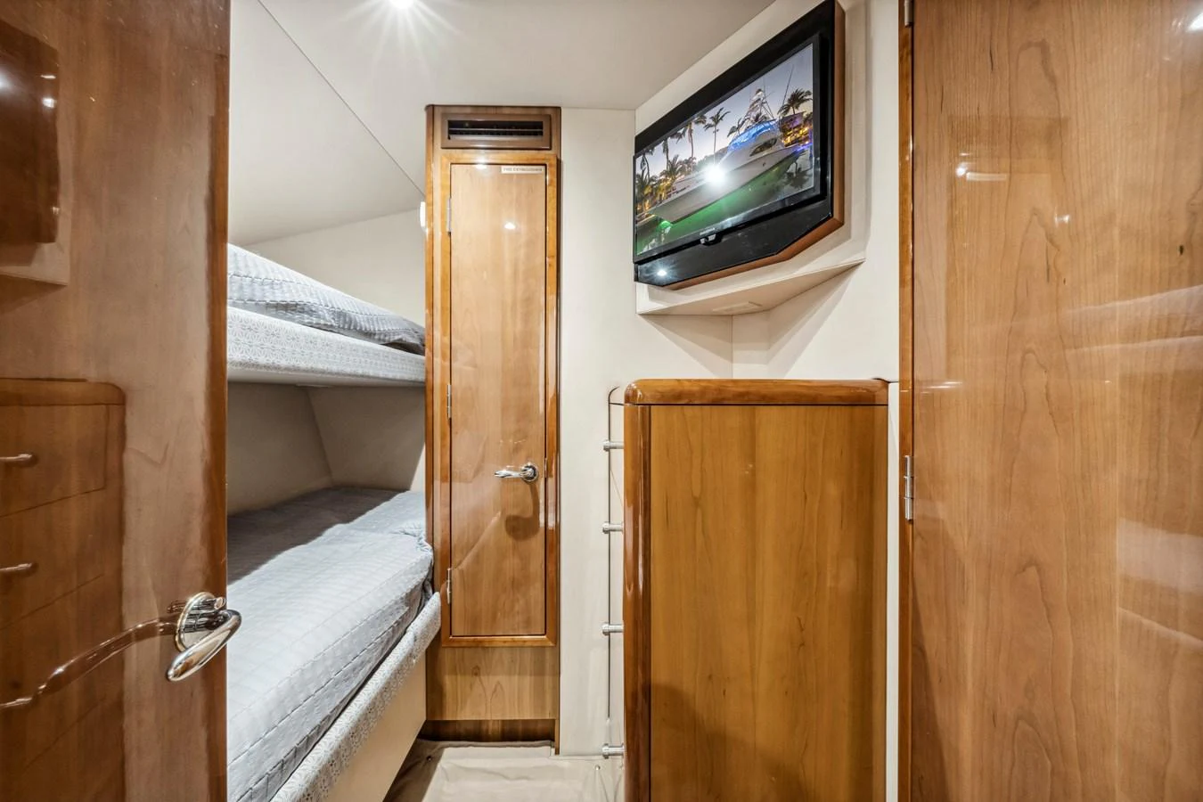 A cozy cabin with bunk beds and a mounted TV offers a comfortable retreat. aboard REEL TEXAN Yacht for Sale