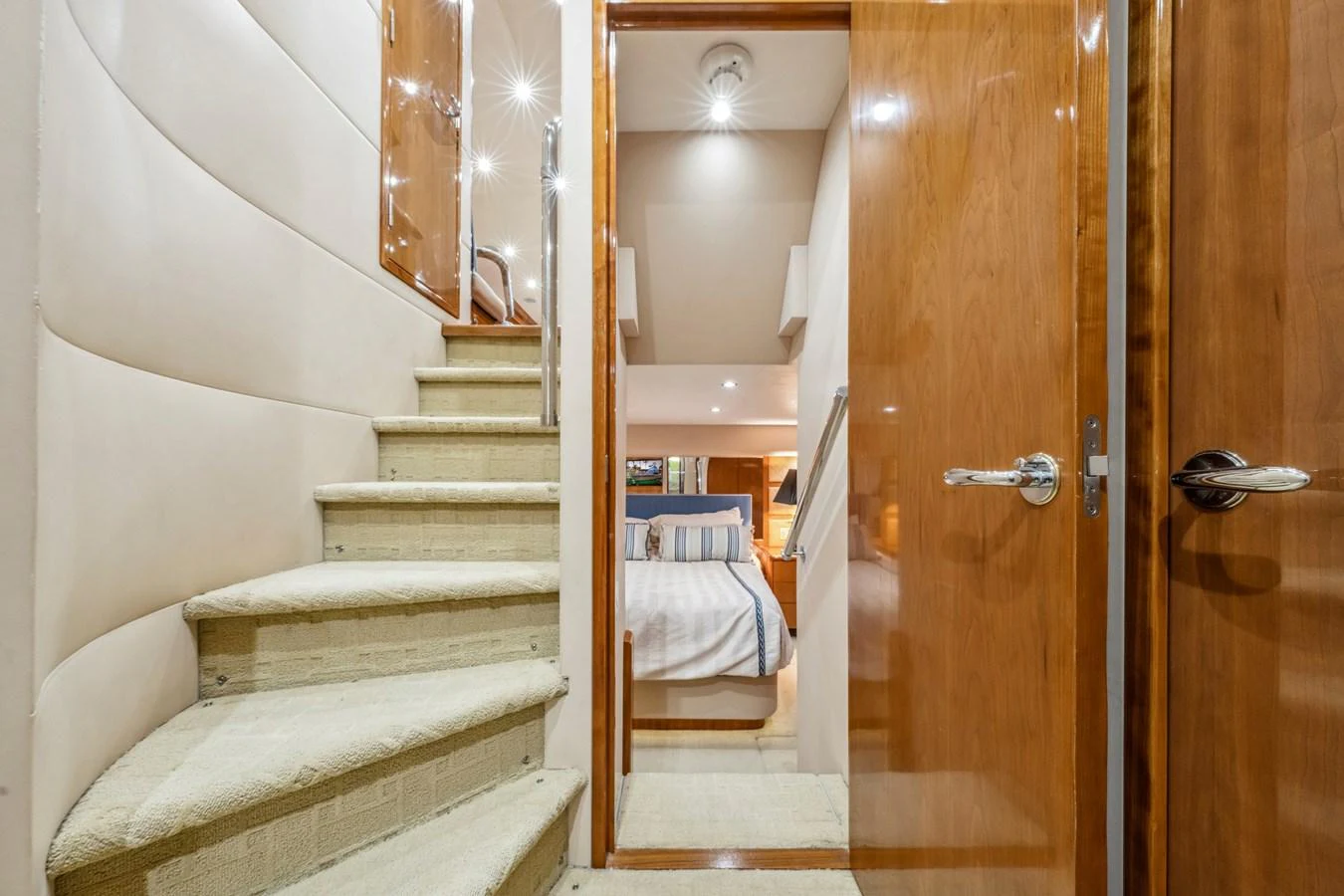The image showcases a cozy and elegant interior with a staircase leading to a well-appointed bedroom. aboard REEL TEXAN Yacht for Sale