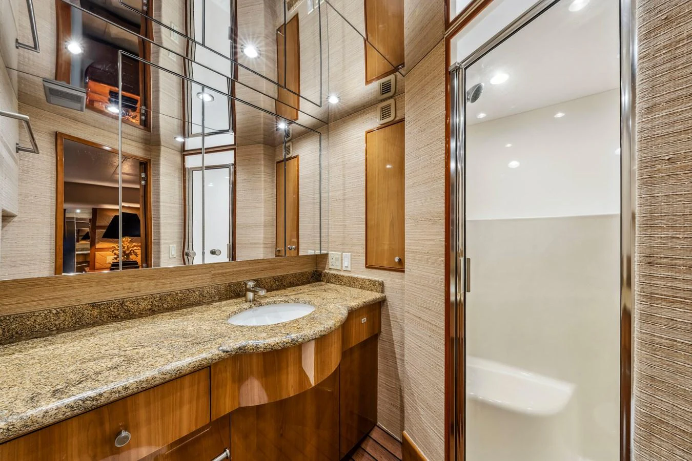 The yacht's bathroom features elegant wood cabinetry and a spacious shower area. aboard REEL TEXAN Yacht for Sale