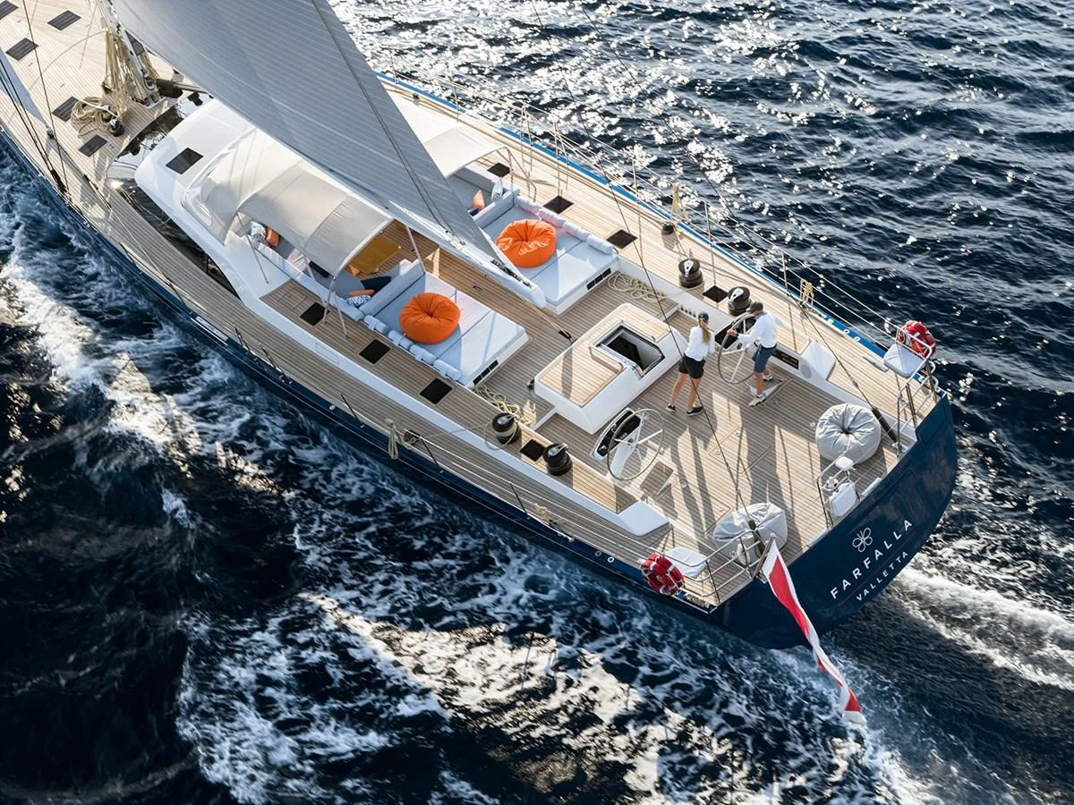 A luxurious sailing yacht glides through the water, showcasing its elegant aft deck with comfortable lounging areas. aboard FARFALLA Yacht for Sale