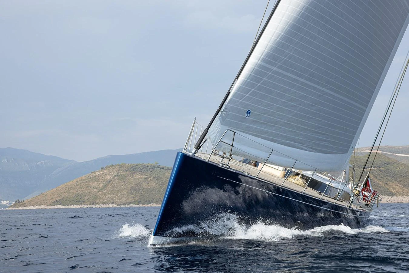 A sleek sailing yacht gracefully cuts through the water with its sails fully extended. aboard FARFALLA Yacht for Sale