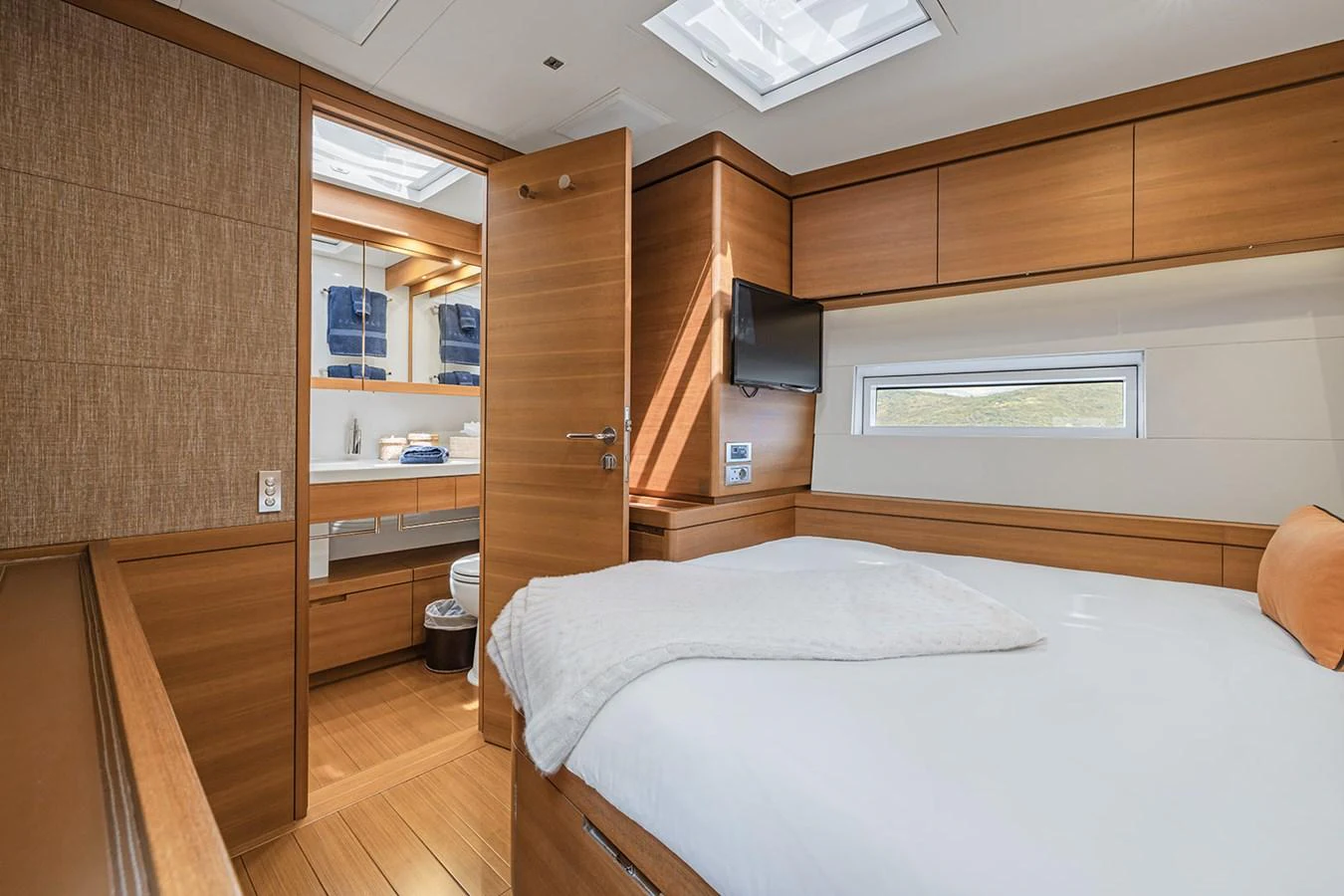 The stateroom features a comfortable bed, modern wood finishes, and ample natural light. aboard FARFALLA Yacht for Sale
