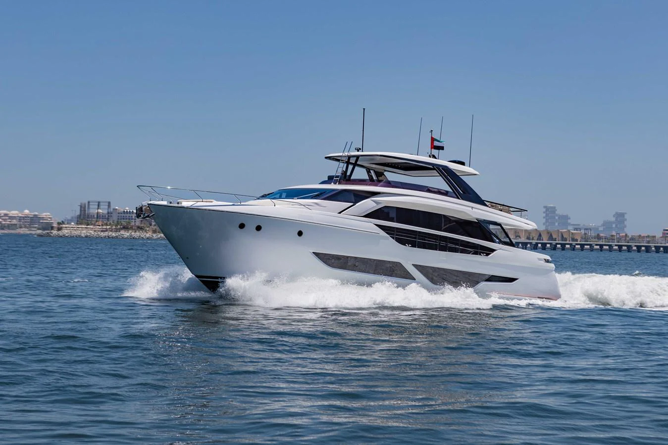 A sleek and modern yacht cruises swiftly on the open water under a clear blue sky. aboard CYRUS Yacht for Sale