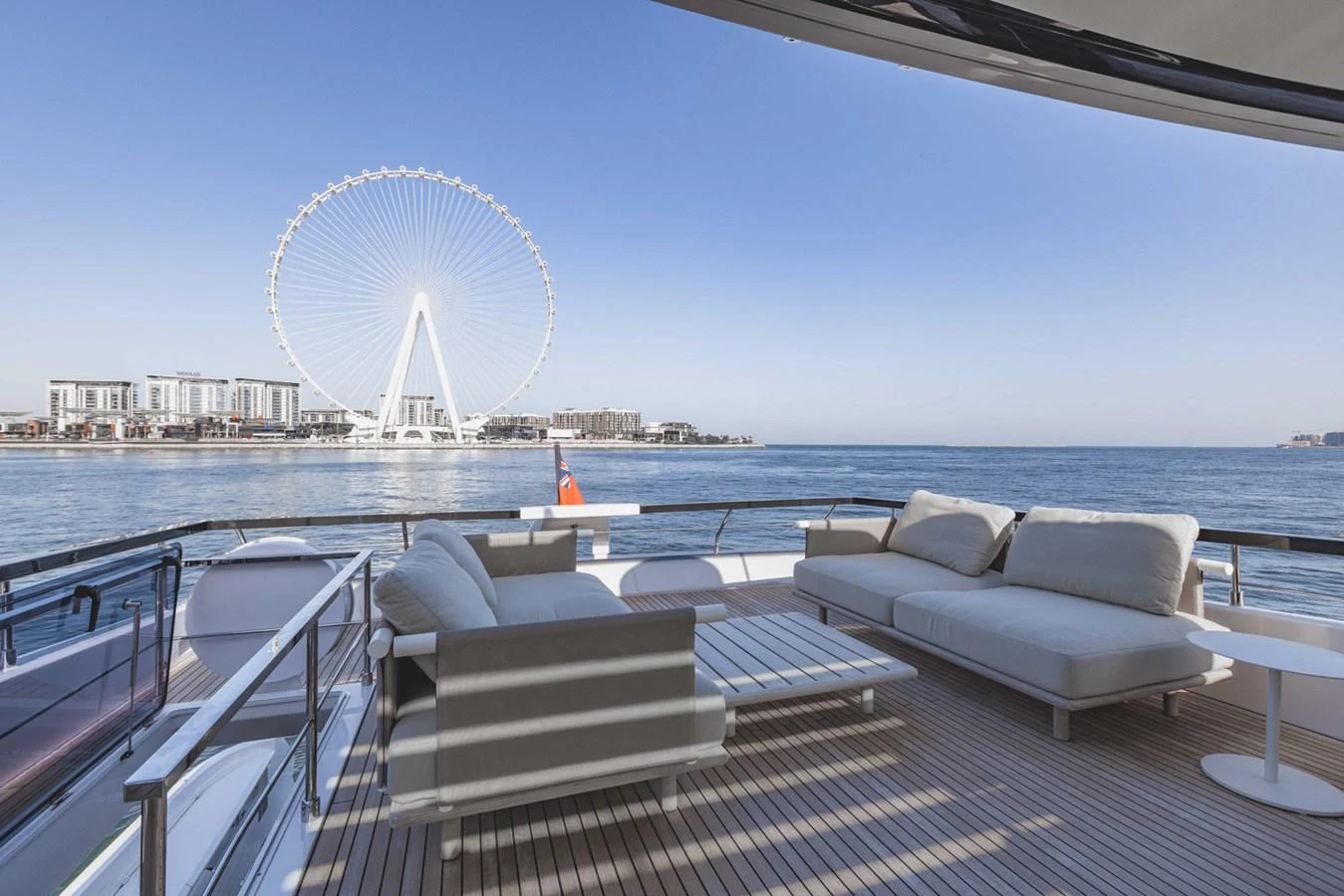 The aft deck offers a spacious and luxurious seating area with stunning views of the waterfront and a Ferris wheel. aboard CYRUS Yacht for Sale
