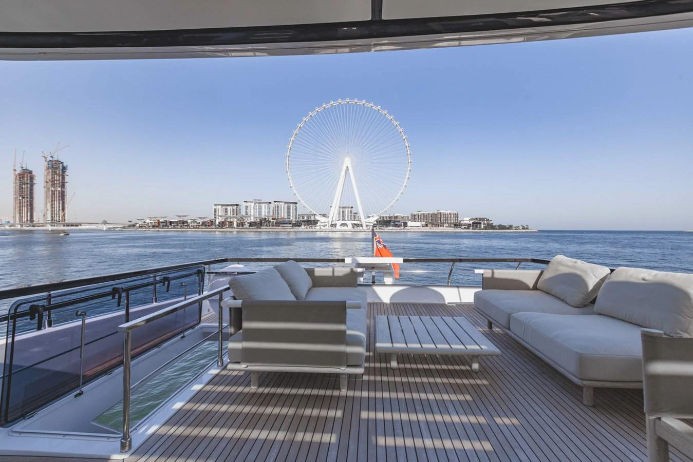 The aft deck offers a stunning view of the waterfront and a large Ferris wheel, with comfortable seating and a spacious layout. aboard CYRUS Yacht for Sale