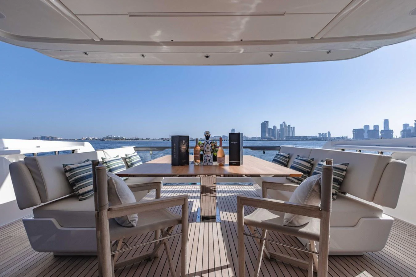 The aft deck features a stylish dining area with a stunning cityscape view. aboard CYRUS Yacht for Sale