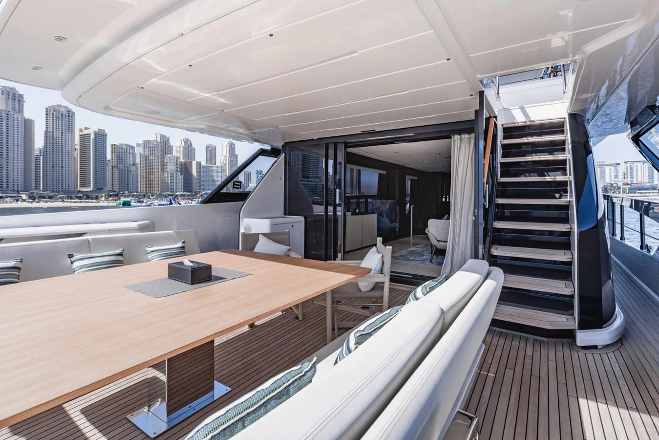 The aft deck offers a spacious and stylish outdoor dining area with a view of the city skyline. aboard CYRUS Yacht for Sale