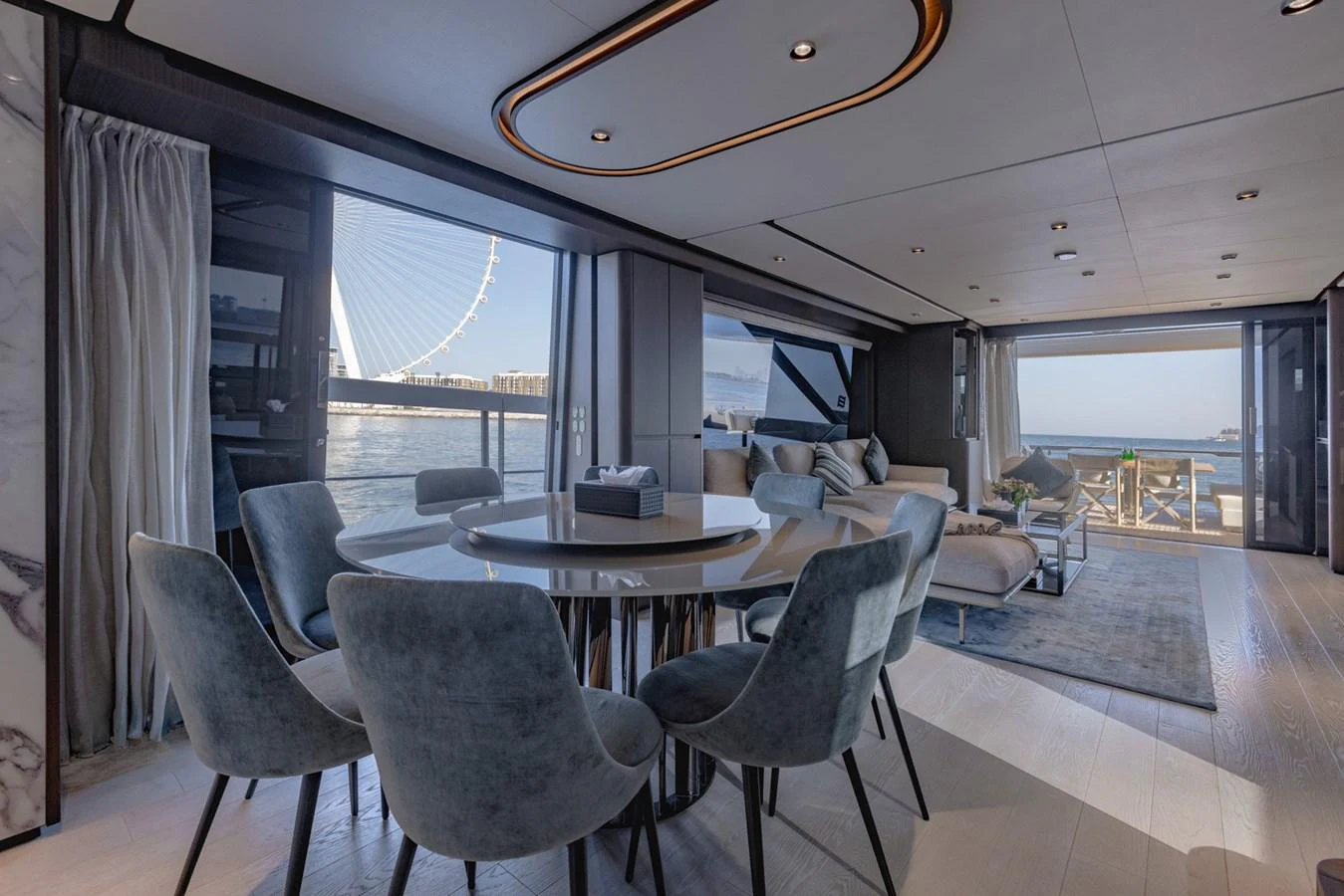 The salon offers a spacious and elegant area with a dining table and comfortable seating, complemented by large windows providing stunning views. aboard CYRUS Yacht for Sale