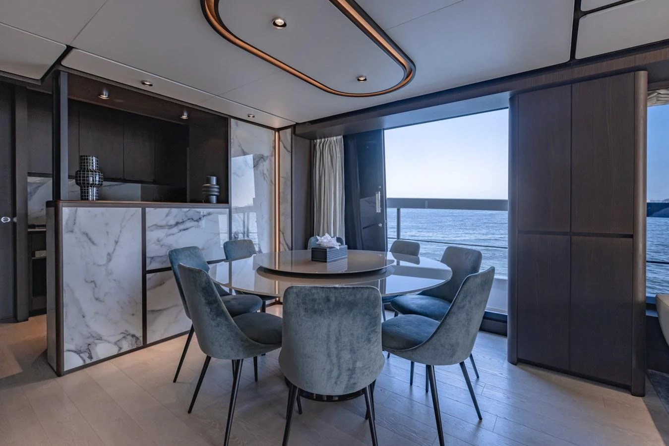 The yacht's dining area features a modern table with plush seating and a stunning ocean view. aboard CYRUS Yacht for Sale